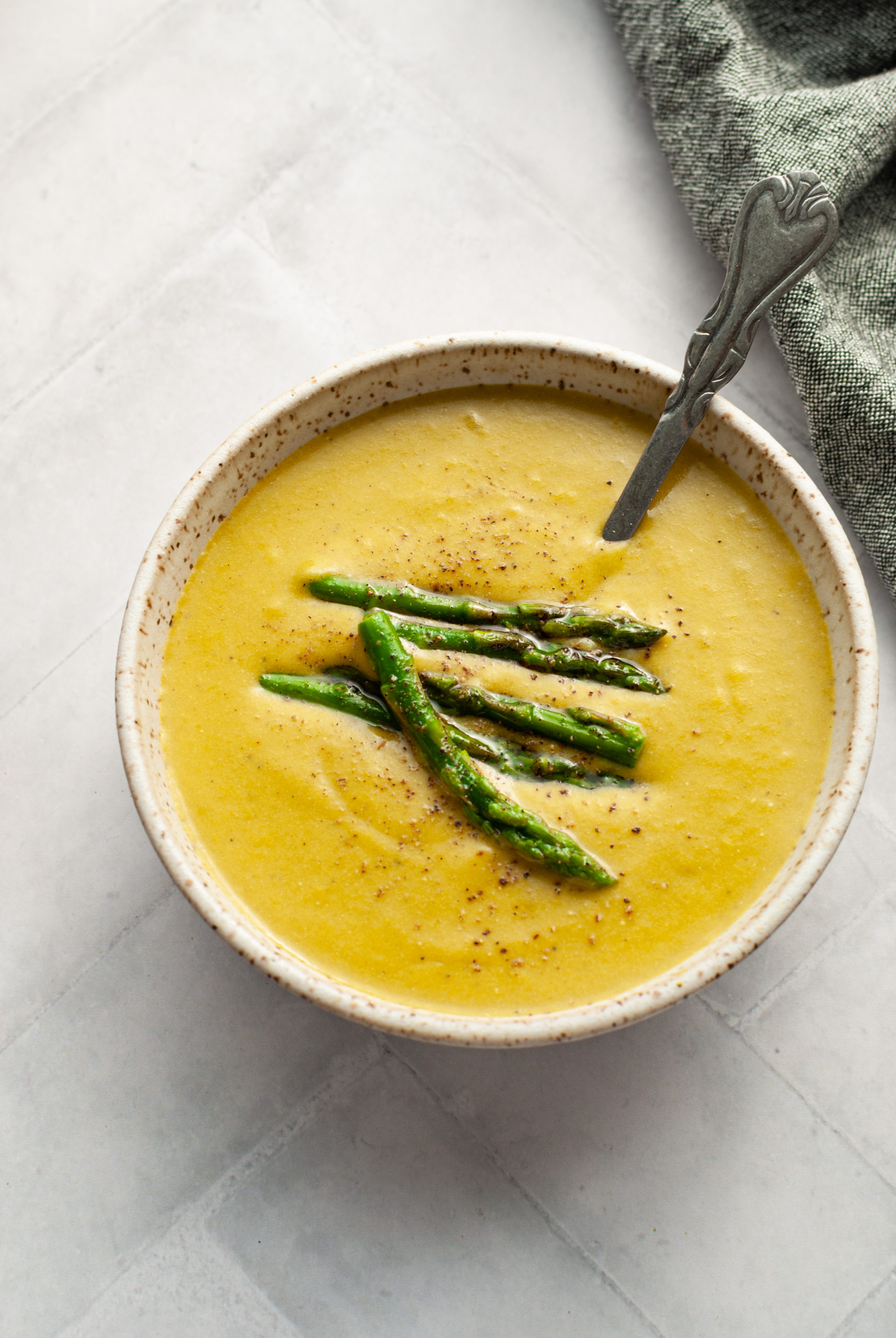 Asparagus soup in a bowl with spoon.