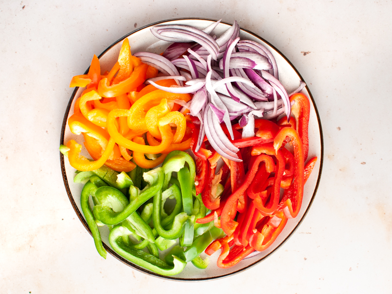 Onion and bell pepper strips in a plate.