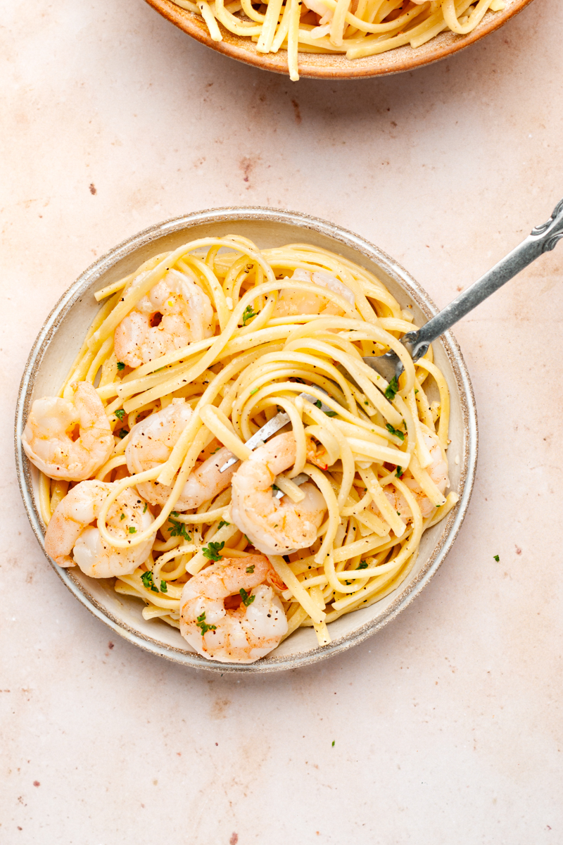 Shrimp scampi with linguine pasta in a plate with fork. 