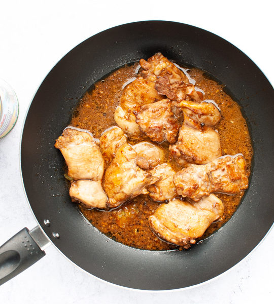 chicken adobo simmering in a pan