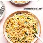 Creamy chickpea pasta in bowl with fork.