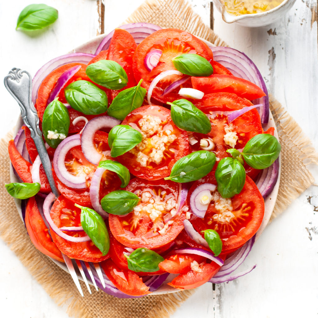 Italian tomato salad in a plate with fork.