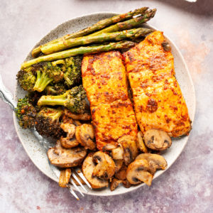 Air fried salmon with asparagus, broccoli and mushrooms in a plate.
