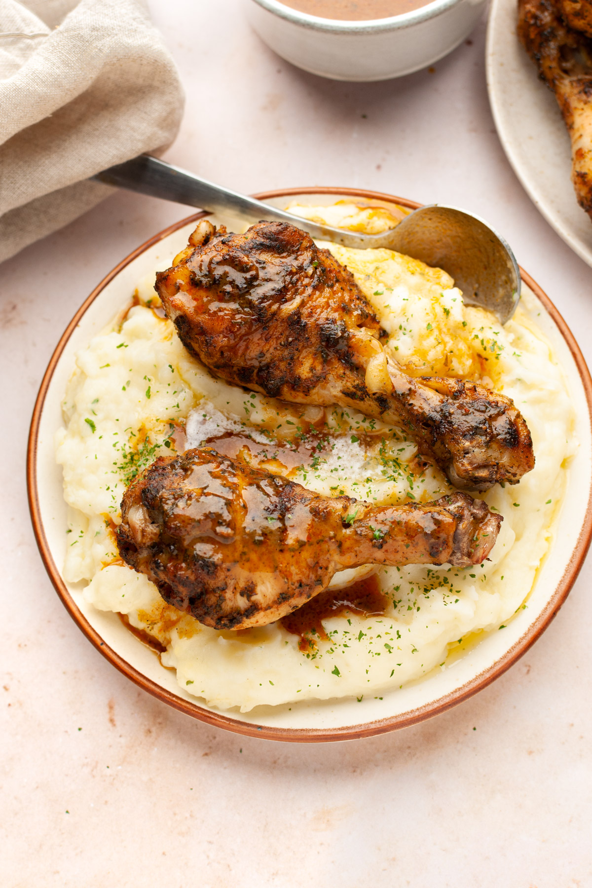 Instant pot chicken drumsticks on a bed of mashed potatoes in a plate.