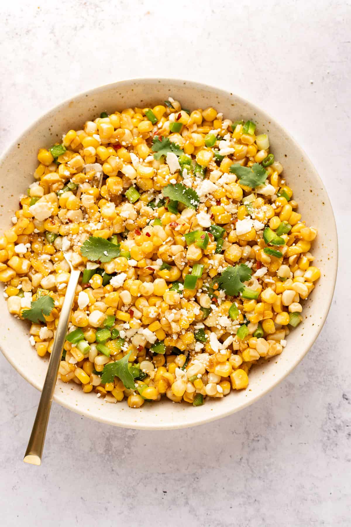 Mexican ttreet corn salad in a bowl with spoon.
