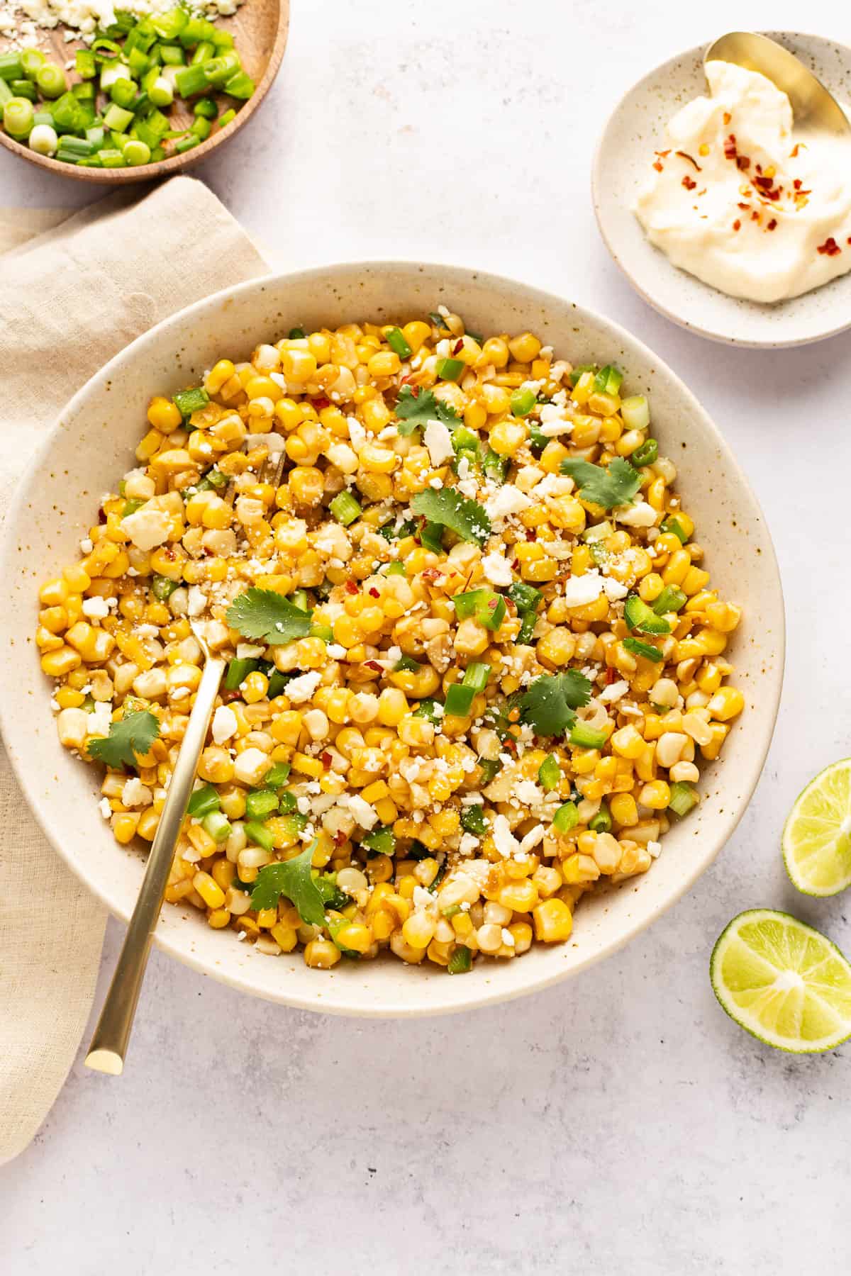 Mexican street corn salad in a bowl with spoon.