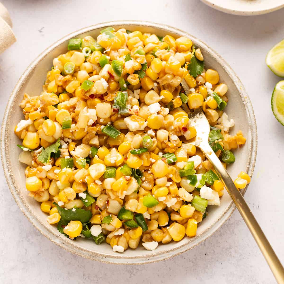 Mexican street corn salad in a plate with spoon.