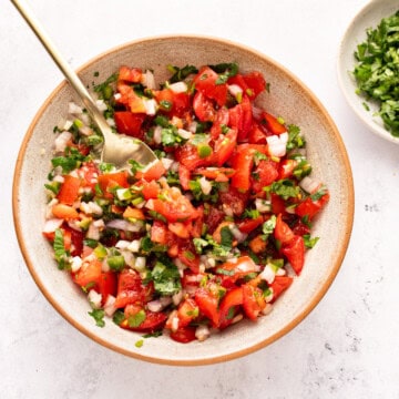 Pico de Gallo in bowl with a spoon.
