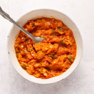 Salsa in a bowl with spoon (roasted in oil).