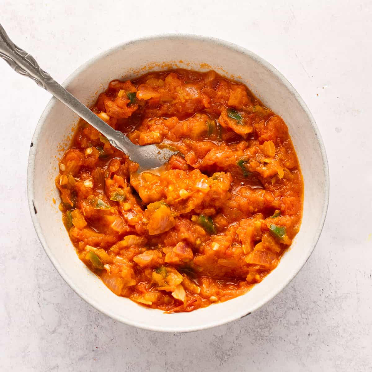 Salsa in a bowl with spoon (roasted in oil).