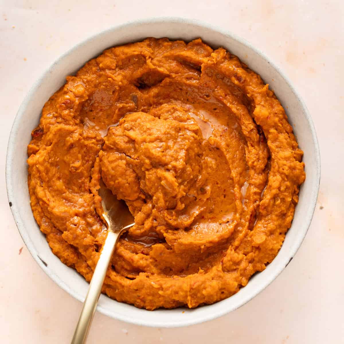 Refried beans in a bowl with a spoon.