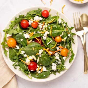 Spinach and arugula salad in a round platter.