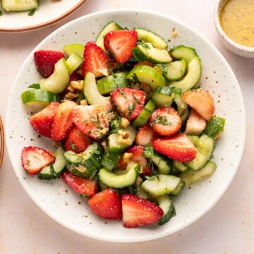Strawberry cucumber salad in a round plate.