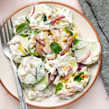 cucumber salad with greek yogurt dressing in a plate with fork.